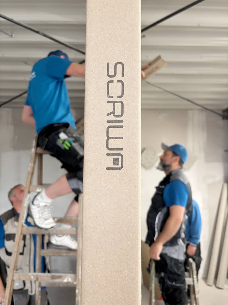 SORIWA Multi Profil im Vordergrund, während Mitarbeiter im Hintergrund an einer Trockenbaukonstruktion arbeiten.